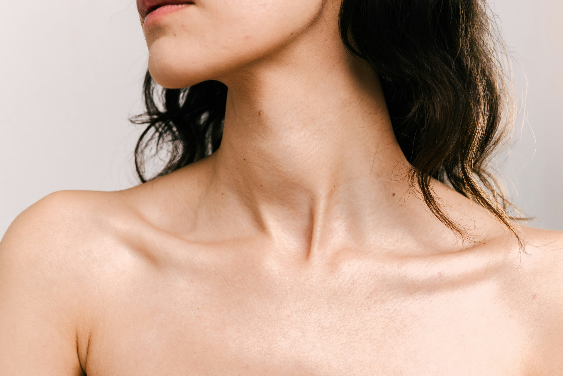 Close study of a woman's neck and collarbones in soft daylight